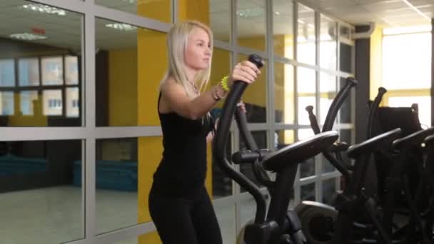 Pretty girl entrenamiento en equipo deportivo especial en el gimnasio — Vídeos de Stock