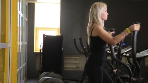 Pretty girl training on special sport equipment in gym — Stock Video