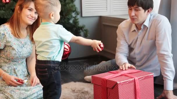 Feliz familia decorando el árbol de Navidad — Vídeo de stock