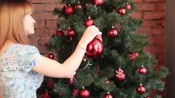 Lächelnde Frau schmückt Weihnachtsbaum zu Hause — Stockvideo