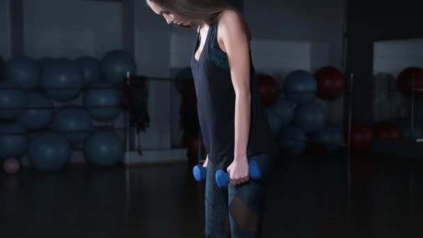 Chica fitness femenina haciendo ejercicio en interiores en el gimnasio — Vídeos de Stock