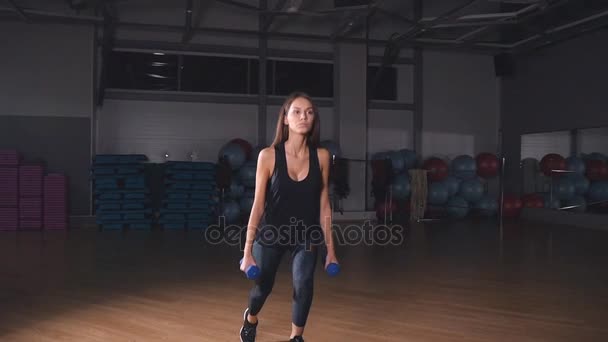 Chica fitness femenina haciendo ejercicio en interiores en el gimnasio — Vídeos de Stock