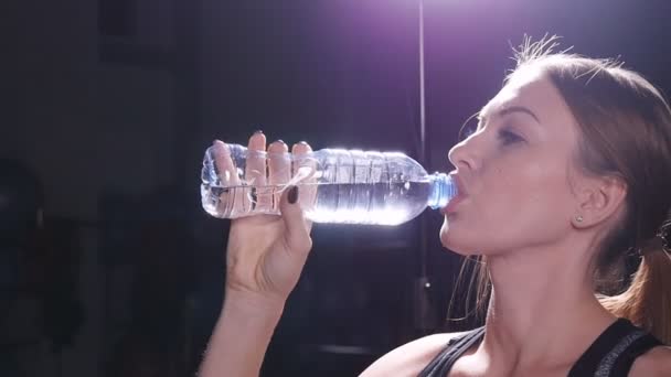 Jovem apto mulher água potável no ginásio — Vídeo de Stock