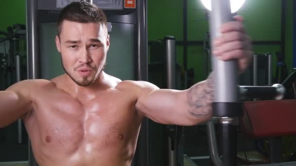Fitness eğitimi makinede bir spor salonunda ağırlık ile atlet — Stok video
