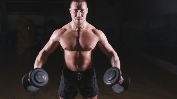 Muskulös bodybuilder killen gör övningar med hantlar — Stockvideo