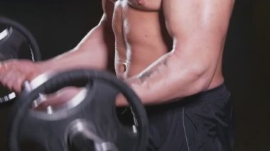 Spor salonunda ağırlık kaldıran bir adam.