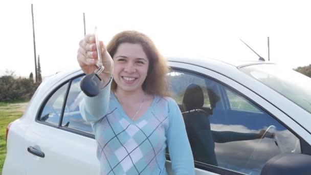 Mujer joven mostrando la llave de un coche nuevo — Vídeos de Stock