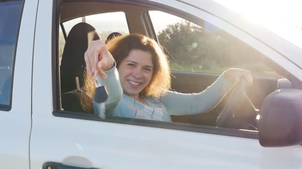 Νεαρή γυναίκα δείχνει κλειδί για ένα νέο αυτοκίνητο — Αρχείο Βίντεο