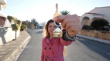 Yeni ev karşı açık ayakta iken anahtarları tutan genç kadın.