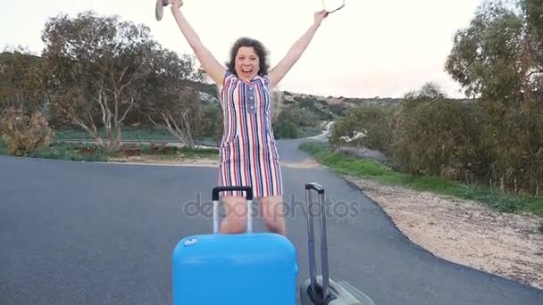 Šťastná mladá žena cestovatele s kufrem tanec