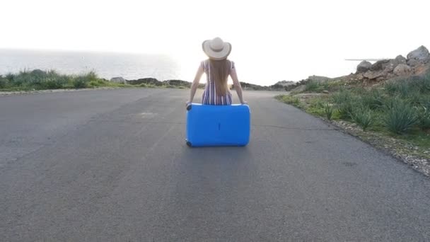 Traveler woman sitting on her suitcase — Stock Video