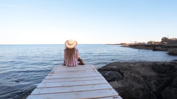 Mujer joven sentada en Pier — Vídeos de Stock