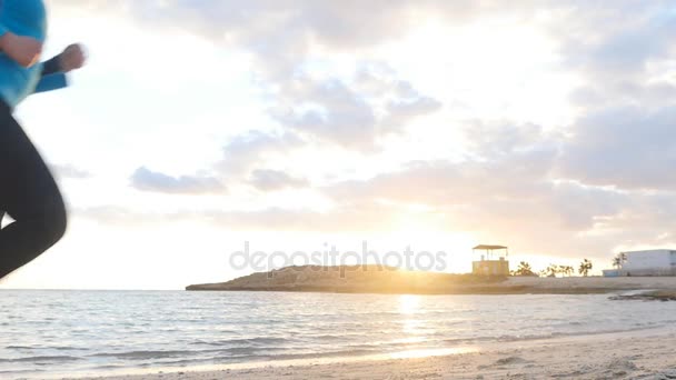 Femme courant sur la plage au coucher du soleil — Video