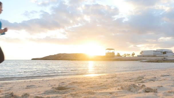 Femme courant sur la plage au coucher du soleil — Video