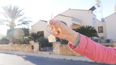 Bir elini yeni evden bir anahtarı tutuyor