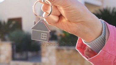 Bir elini yeni evden bir anahtarı tutuyor