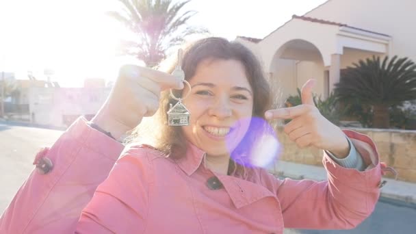 Genç kadın anahtarları için yeni bir ev tutar. — Stok video