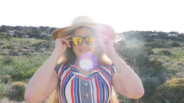 Μια γυναίκα σε ένα καπέλο και γυαλιά ηλίου στις διακοπές — Αρχείο Βίντεο