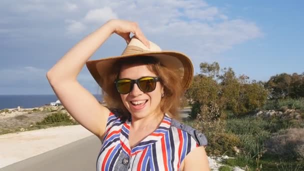 Una mujer con sombrero y gafas de sol de vacaciones — Vídeos de Stock