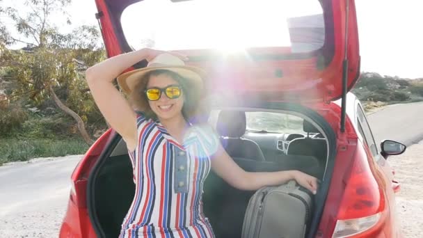 Jeune femme avec valise dans le coffre de la voiture — Video