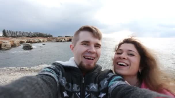 Framgångsrika resande par i kärlek tar en selfie på stranden — Stockvideo