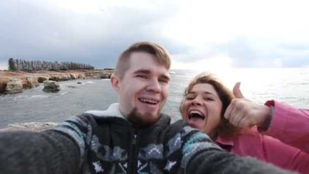 Framgångsrika resande par i kärlek tar en selfie på stranden — Stockvideo