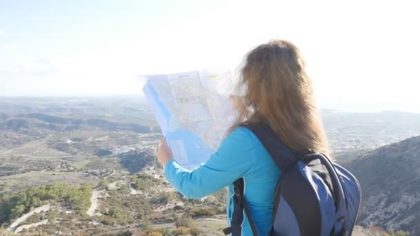 Mujer excursionista leyendo un mapa junto al arroyo — Vídeo de stock