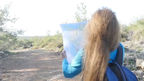 Kvinna hiker läsa en karta bredvid ström — Stockvideo