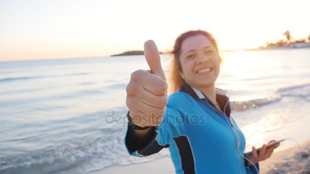 Jovem mulher dando polegares para cima sinal de mão na praia — Vídeo de Stock