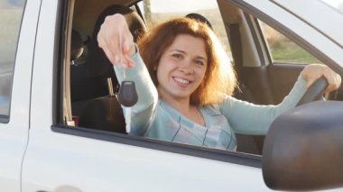 Yeni araba için genç kadın gösteren anahtar