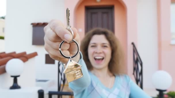 Ung kvinna håller en nyckel i hand från ett nytt hus — Stockvideo