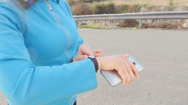 彼女のスマートな腕時計を使用して女性ランナー選手 — ストック動画