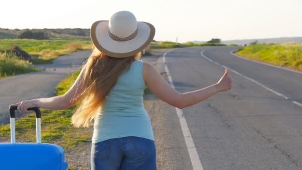 Mujer haciendo autostop junto a la carretera — Vídeo de stock