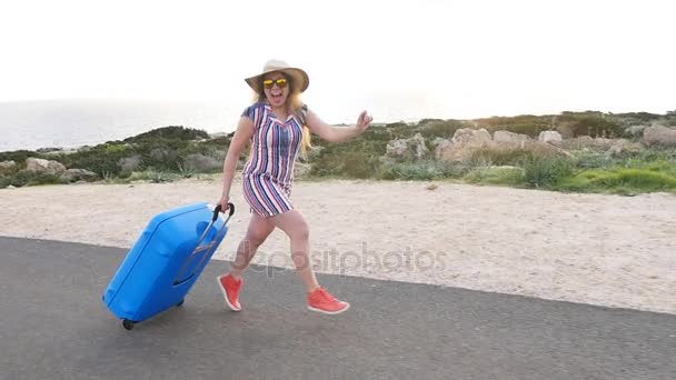 Happy traveler woman running with suitcase