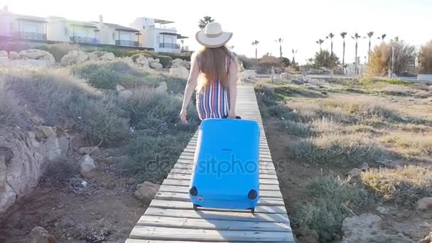 Giovane donna felice in vacanza in un cappello con una valigia — Video Stock