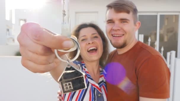 Happy νεαρό ζευγάρι με τα κλειδιά στο νέο σπίτι — Αρχείο Βίντεο