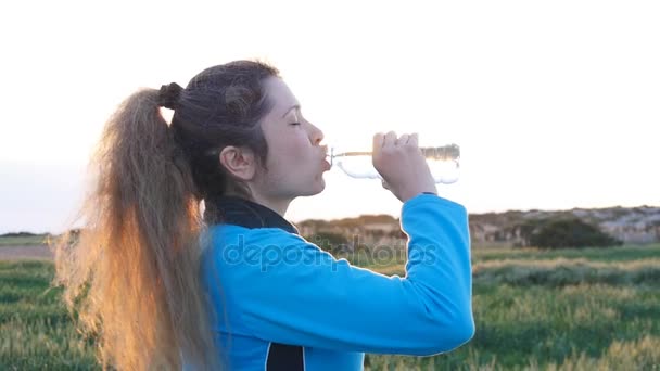 Красивая спортсменка фитнес питьевая вода после тренировки — стоковое видео