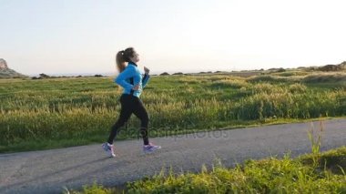 Gündoğumu yolda çalışan genç kadın atlet. Fitness kavramı