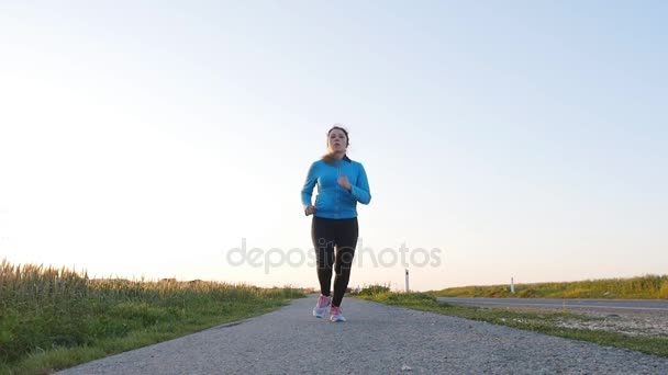 Young woman runner running on sunrise road. Fitness concept — Stock Video