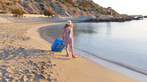 Ελκυστική νεαρή γυναίκα με βαλίτσα στην παραλία. — Αρχείο Βίντεο