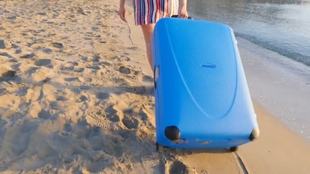 Aantrekkelijke jonge vrouw met koffer op het strand. — Stockvideo