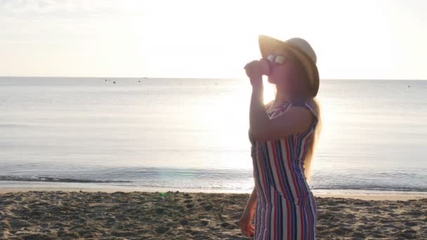 Jeune femme buvant du café sur la plage — Video