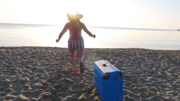 Gelukkige vrouw travaler uitgevoerd op het strand terug naar camera — Stockvideo