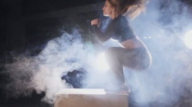 Çapraz Eğitim spor salonu bazı kutularda üstünden atlayarak sportif genç kadın