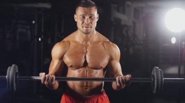 Spor salonunda ağırlık kaldıran bir adam.