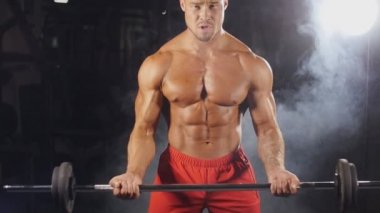 Spor salonunda ağırlık kaldıran bir adam.