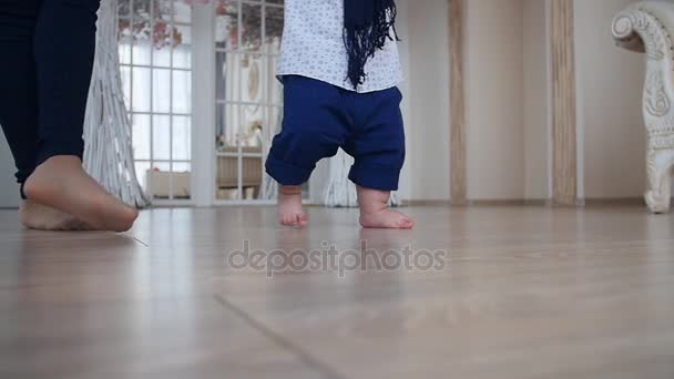 Mother and little boy walking on wood floor at home — Stock Video