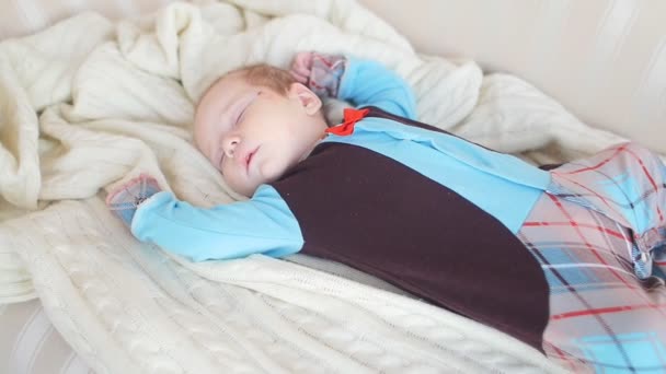 Мирное дитя лежит на кровати во время сна — стоковое видео