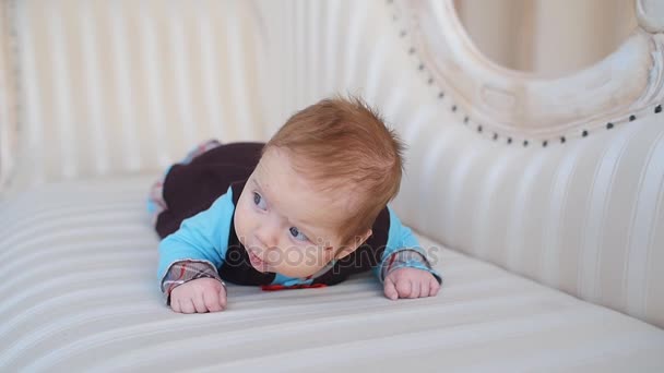 Немовля лежить на дивані — стокове відео