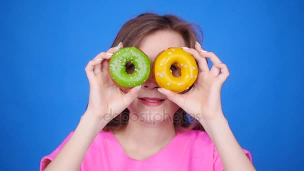 Mulher de beleza tomando donuts coloridos. Menina alegre engraçado com doces — Vídeo de Stock